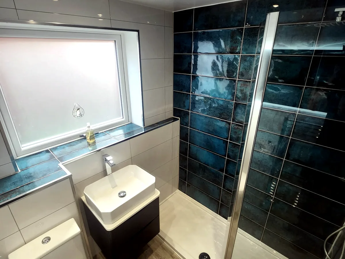 Completed marble bathroom installation with black fittings