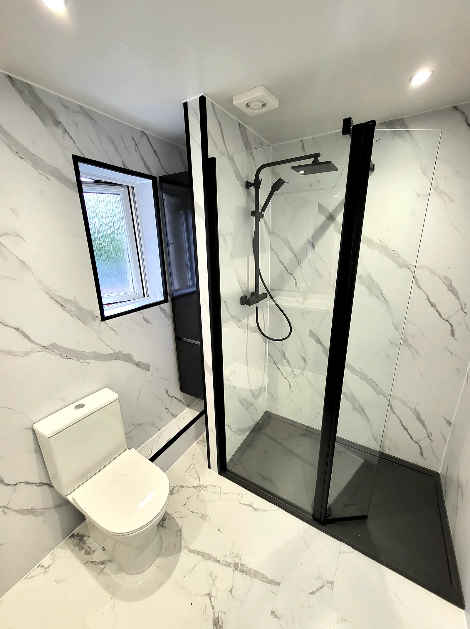Recently completed marble bathroom installation with black fittings
